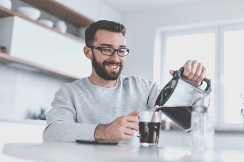 man and coffee pot at home