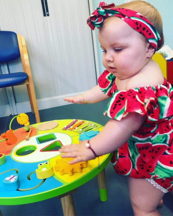 baby playing in watermelon onesie